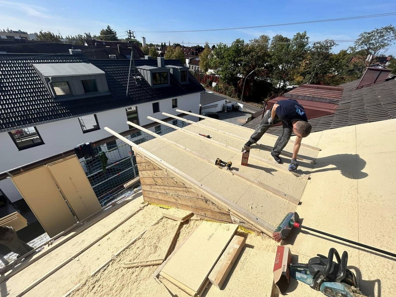 Handwerker verlegt Holzfaser-Dämmplatten und Lattung auf einem Dach